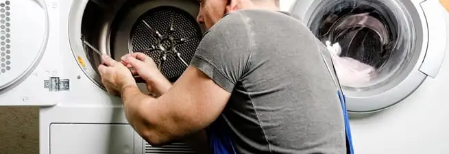 Dryer repair technician fixing a clothes dryer drum in Green Bay, WI