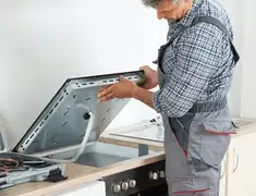 Appliance repair technician installing a built-in cooktop in Green Bay, WI
