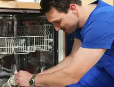 Dishwasher repair technician inspecting and servicing an open dishwasher in Green Bay, WI