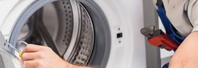 Appliance technician repairing a clothes dryer drum and internal parts in Green Bay, WI