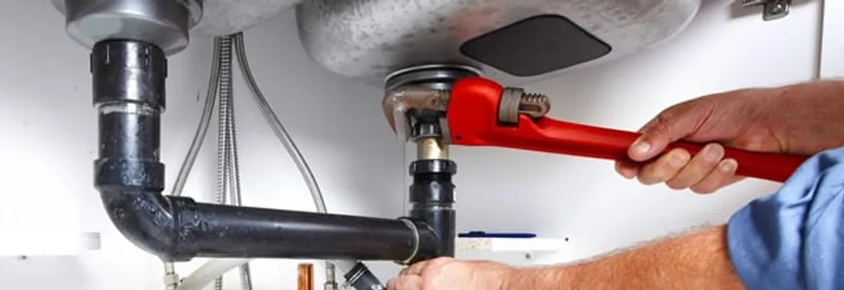 Garbage disposal repair technician tightening the sink drain and disposal connection in Green Bay, WI