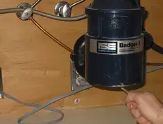 Garbage disposal repair technician tightening the mounting ring under a sink in Green Bay, WI