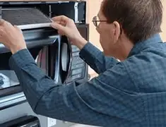Appliance repair technician replacing a microwave vent filter in Green Bay, WI