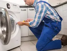 Washing machine repair technician servicing a front-load washer in Green Bay, WI