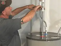 Water heater repair technician tightening supply line connections in Green Bay, WI