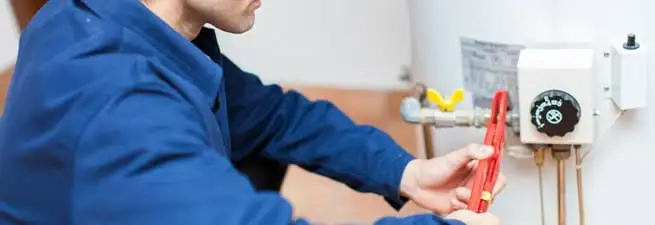 Water heater repair technician adjusting the temperature control and gas valve in Green Bay, WI